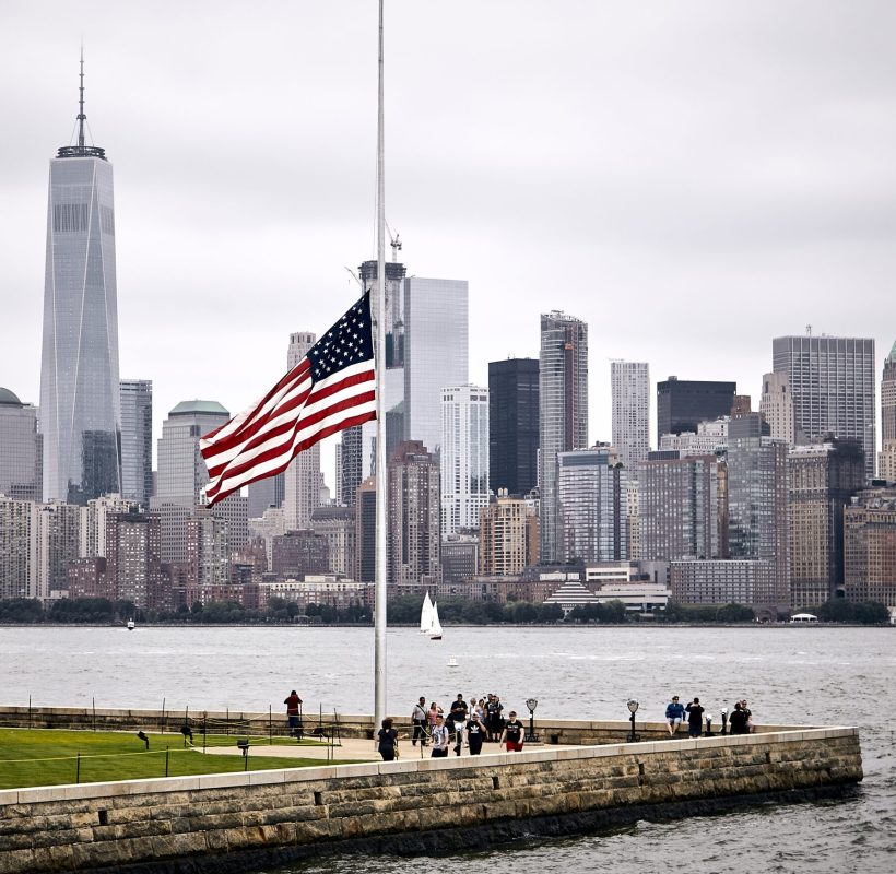 An amazing shot of the US flag in a park on the Manhattan skyline background