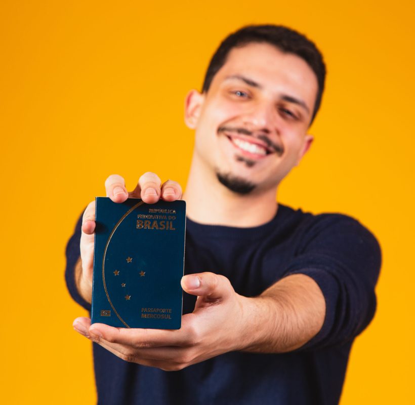 Portrait of a boy holding a Brazilian passport in his hands. Travel and migration concept